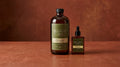 Amber glass bottles of BIOCENTIC castor oil on a warm reddish-brown ground.